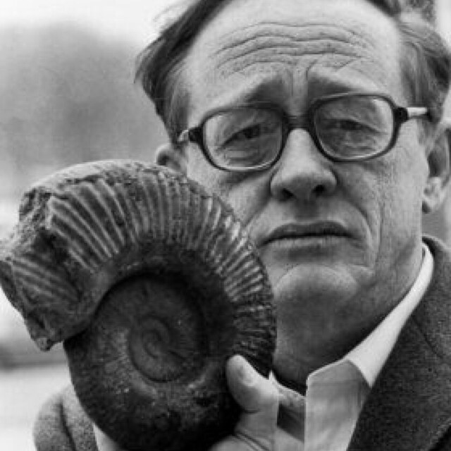 Photograph of paleontologist David M. Raup holding an ammonite